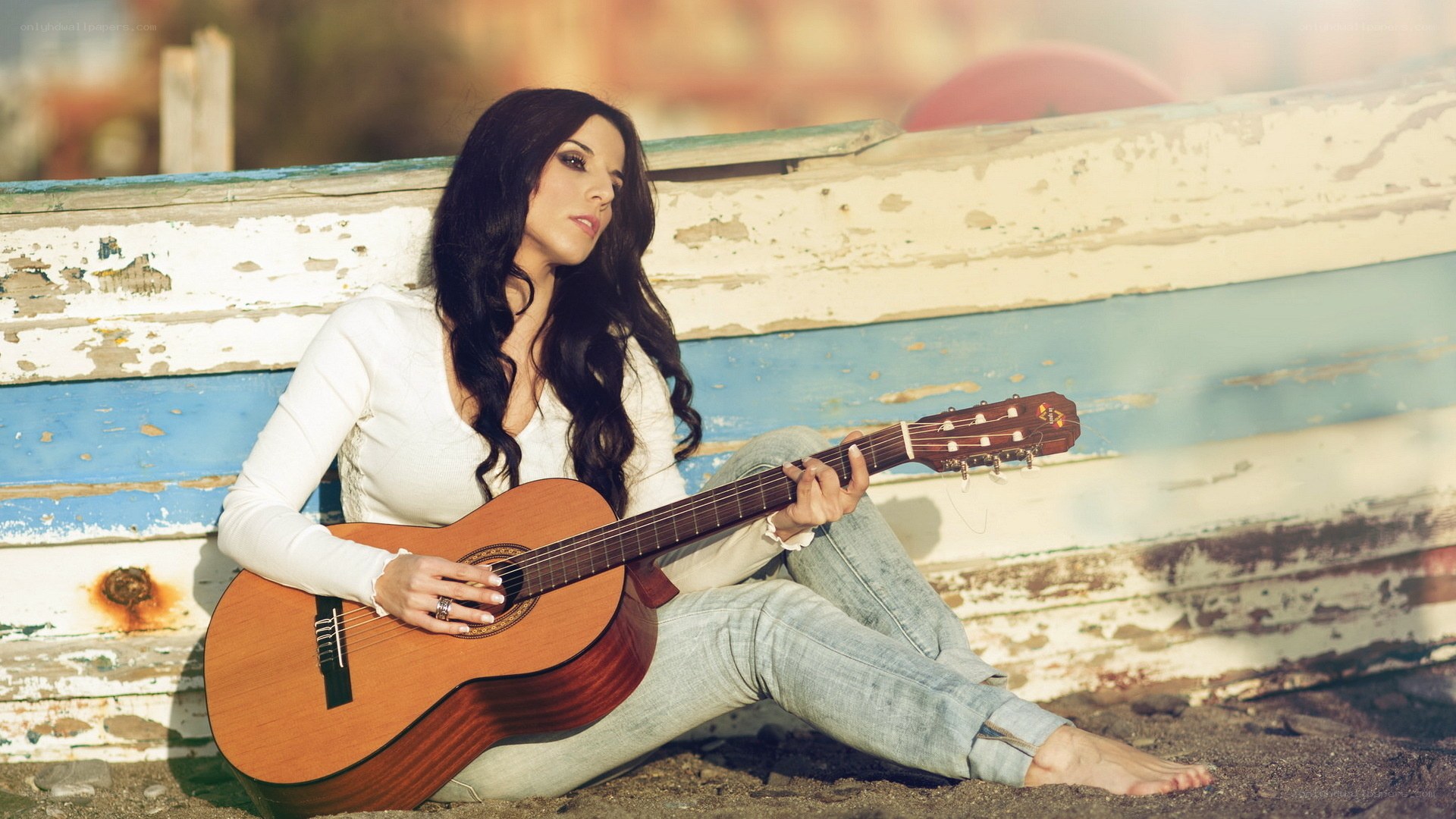 woman with guitar on beach