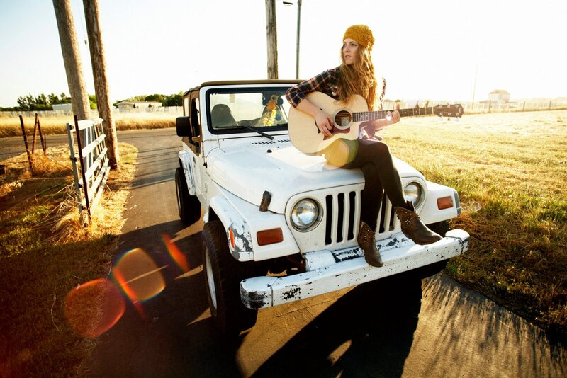 Woman with guitar on jeep