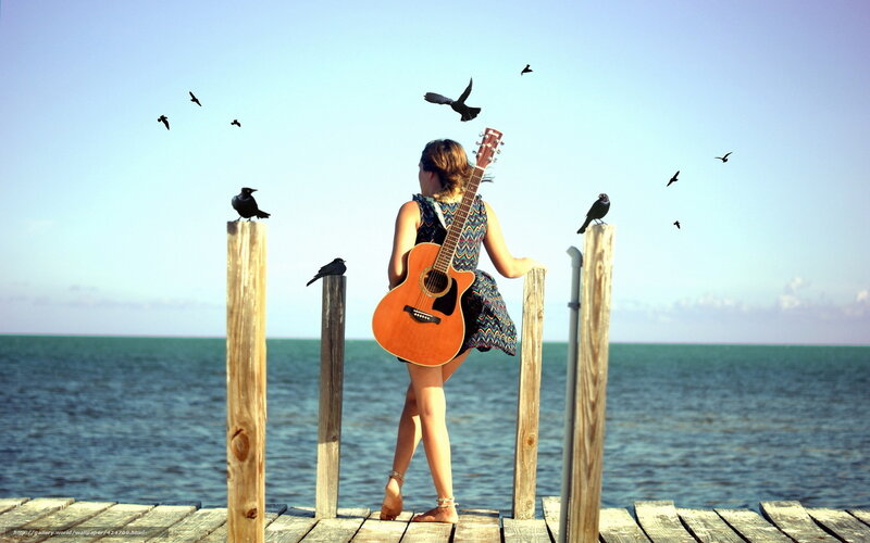 Woman with guitar on pier