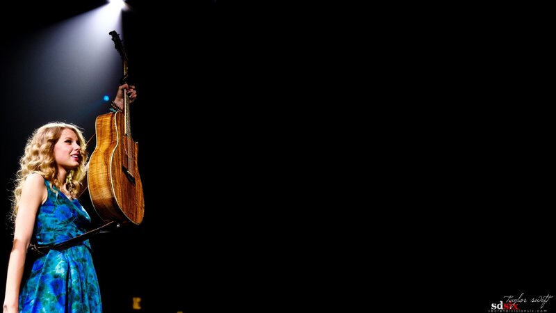 woman with guitar on stage