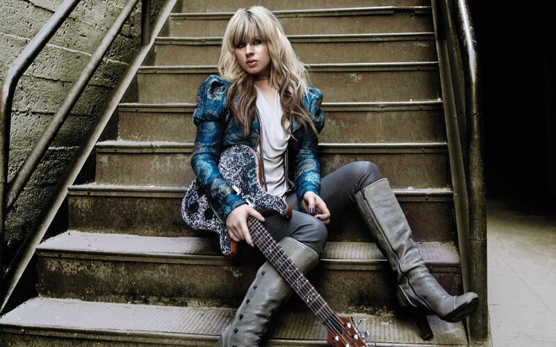 woman with guitar on stairs