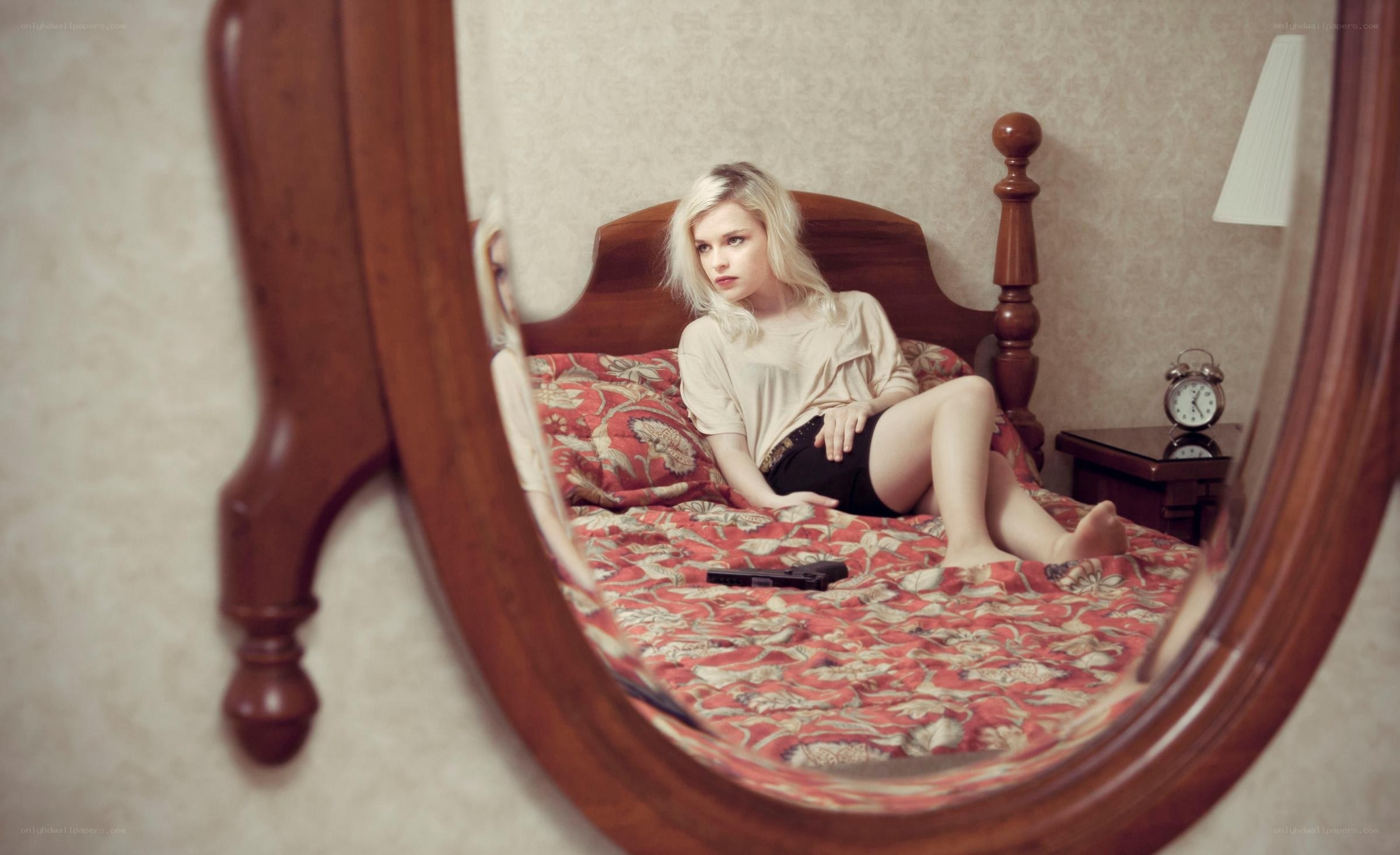 Woman with gun in bed