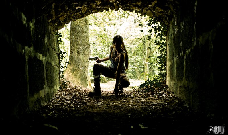 Woman with gun in forest tunnel