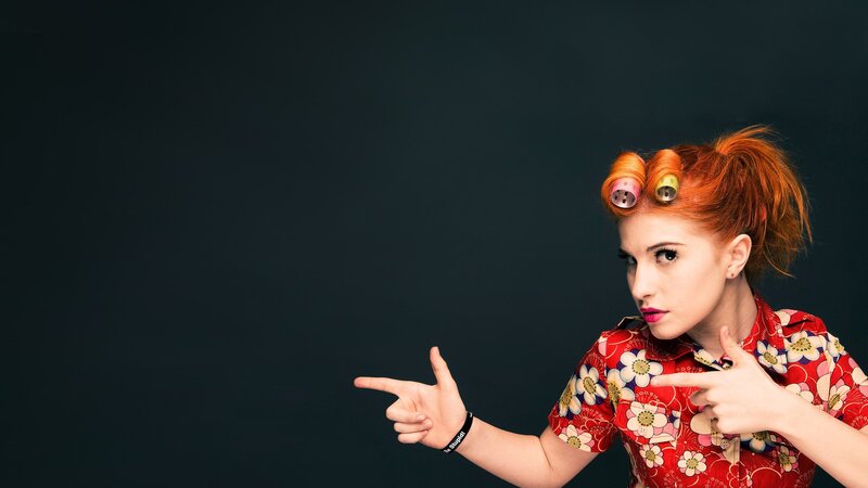 woman with hair rollers pointing