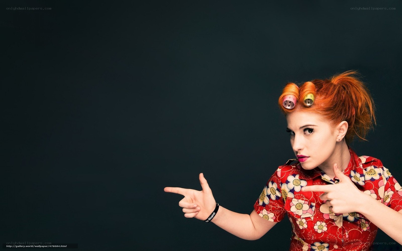woman with hair rollers pointing