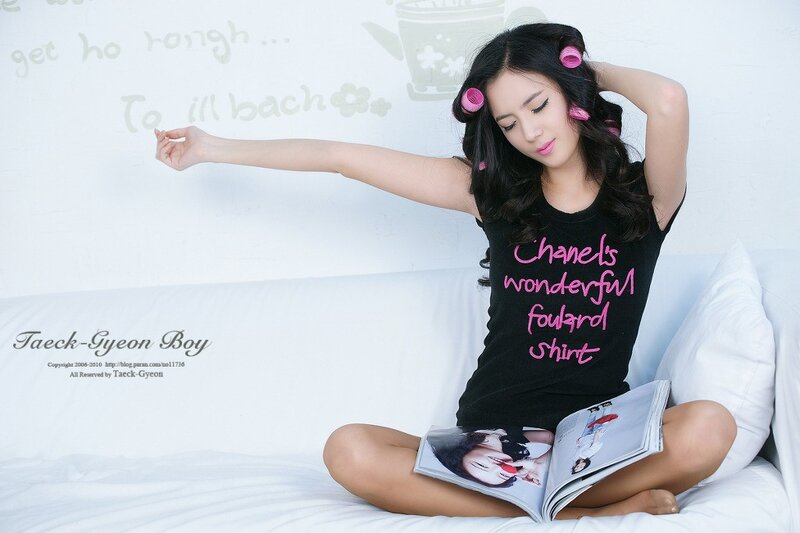 woman with hair rollers reading magazine