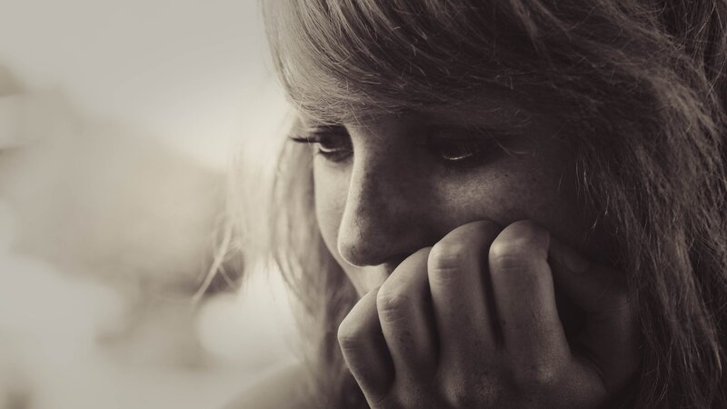 woman with hand on face