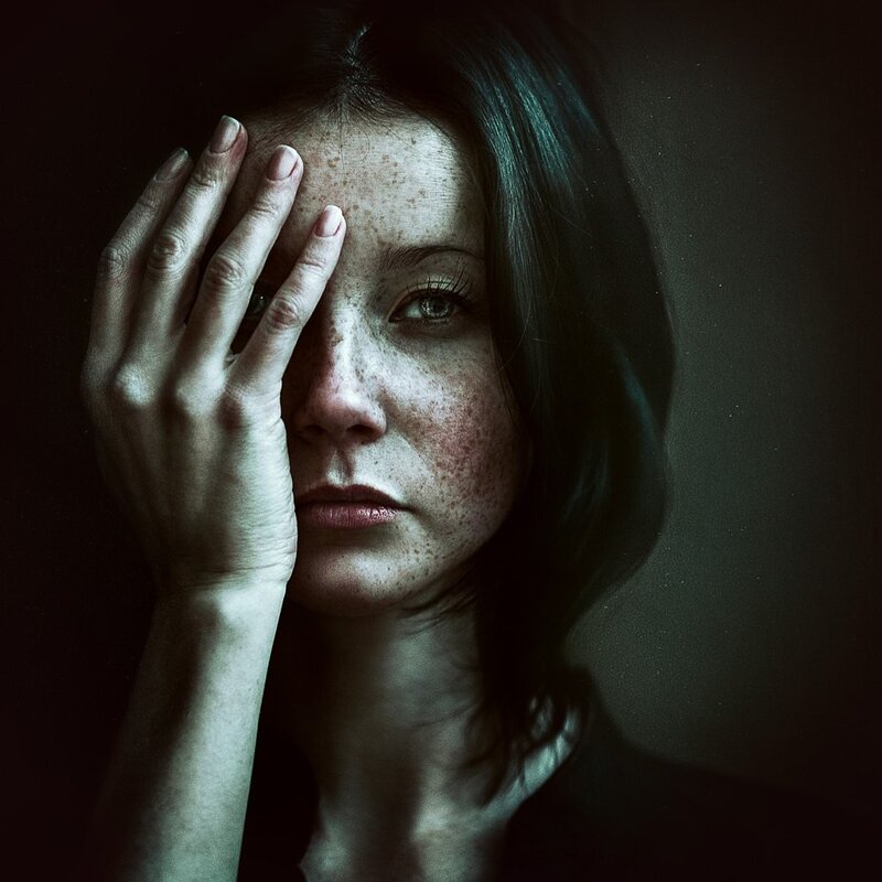 woman with hand on face