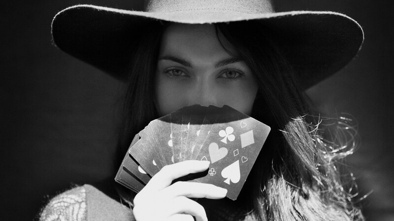 woman with hat holding cards
