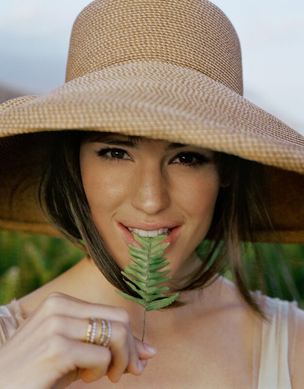 woman with hat holding fern