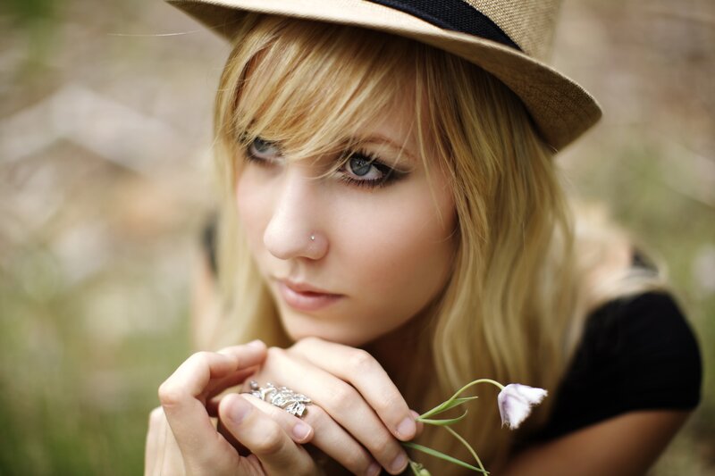 woman with hat holding flower