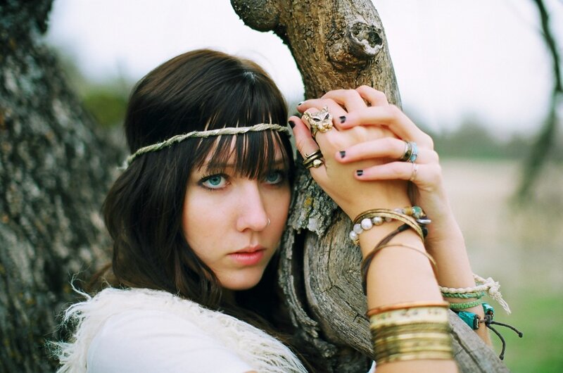 woman with headband leaning on tree