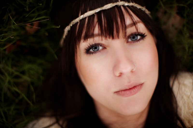 woman with headband lying in grass