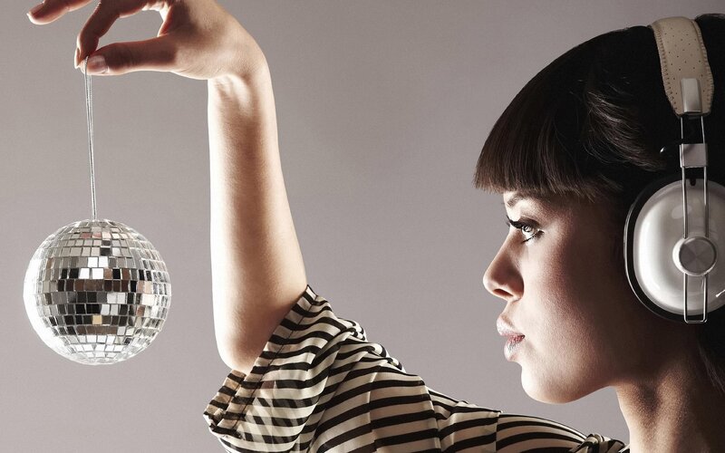 woman with headphones and disco ball
