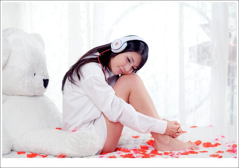 woman with headphones and teddy bear