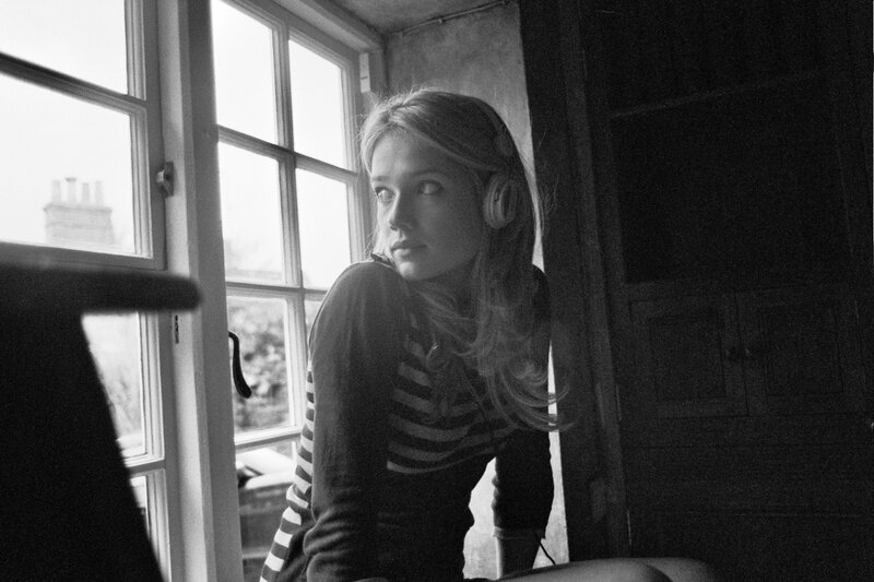 woman with headphones by window