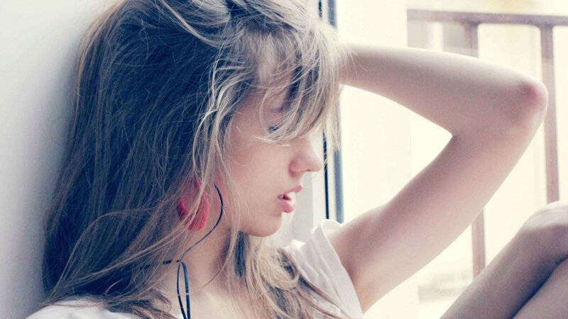 woman with headphones by window