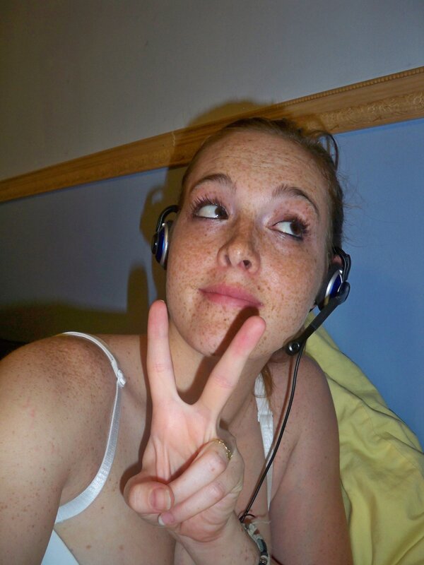 woman with headphones making peace sign