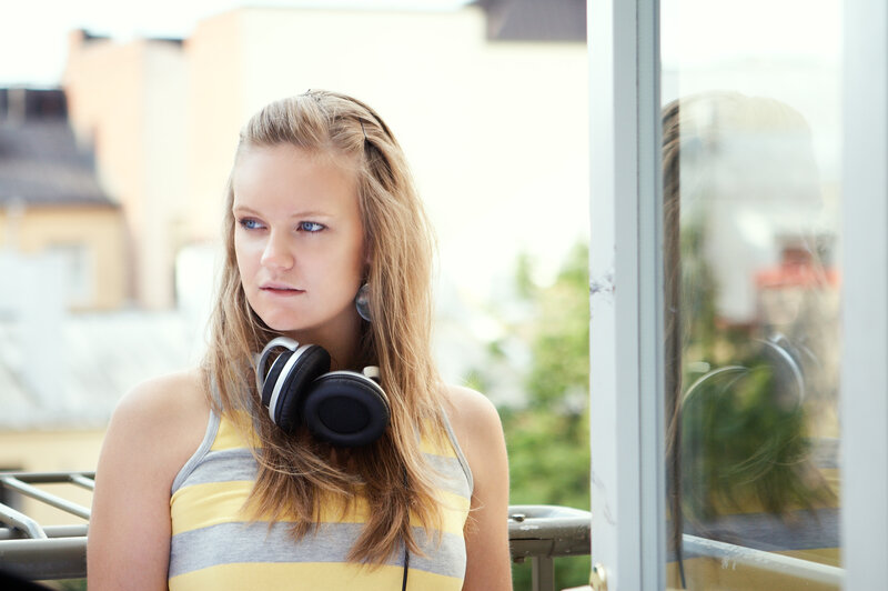 woman with headphones on balcony