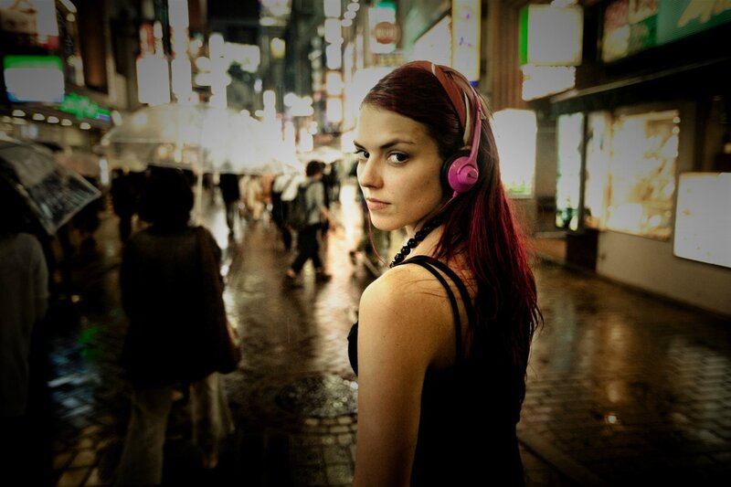 woman with headphones on city street