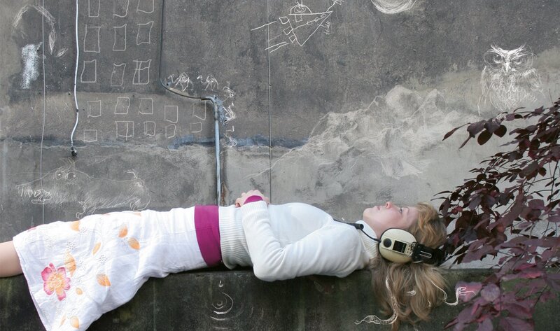 Woman with headphones on wall