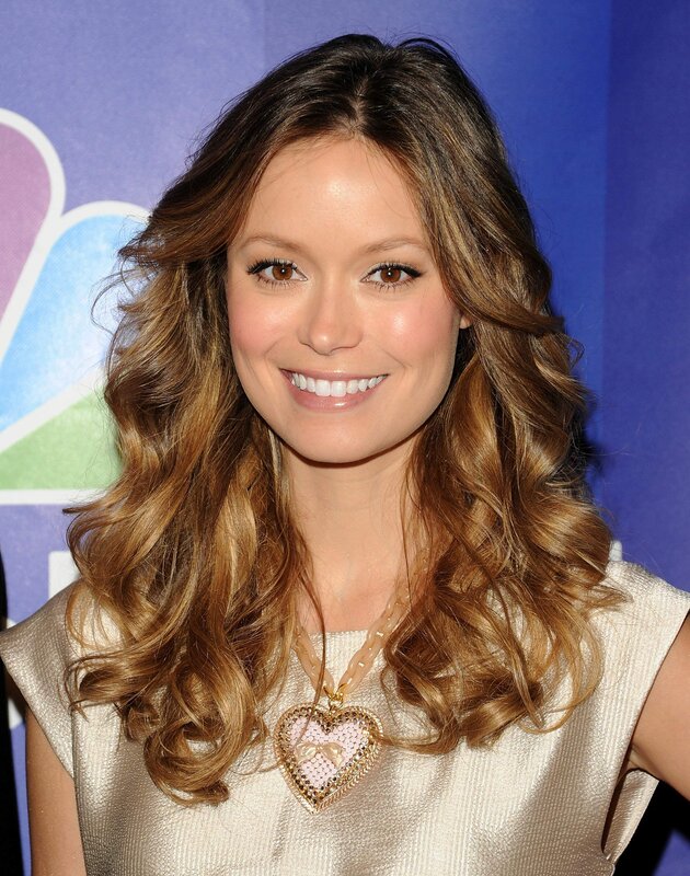 woman with heart necklace smiling
