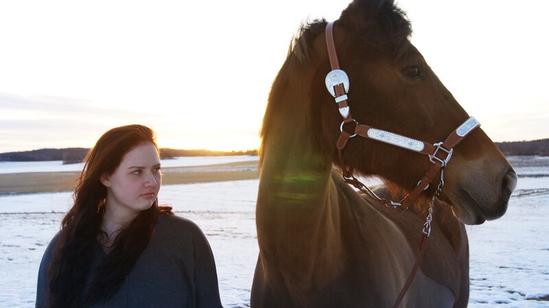 Woman with horse at sunset