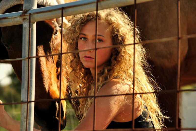 woman with horse behind fence