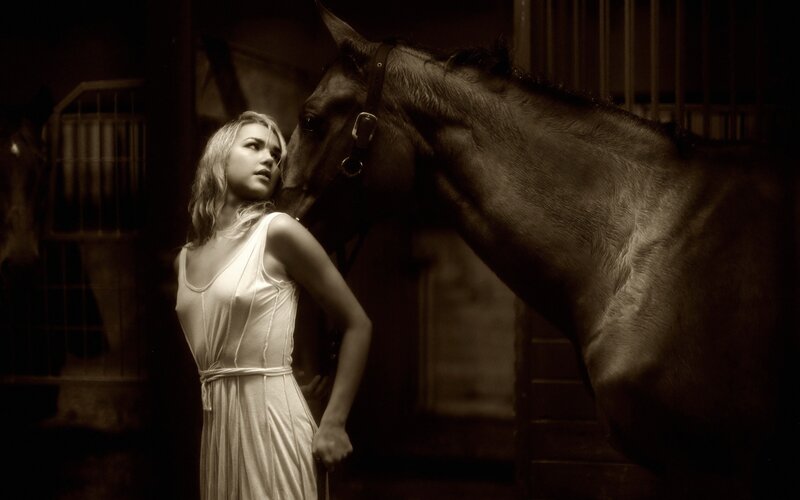 woman with horse in stable