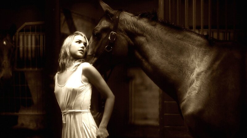 woman with horse in stable