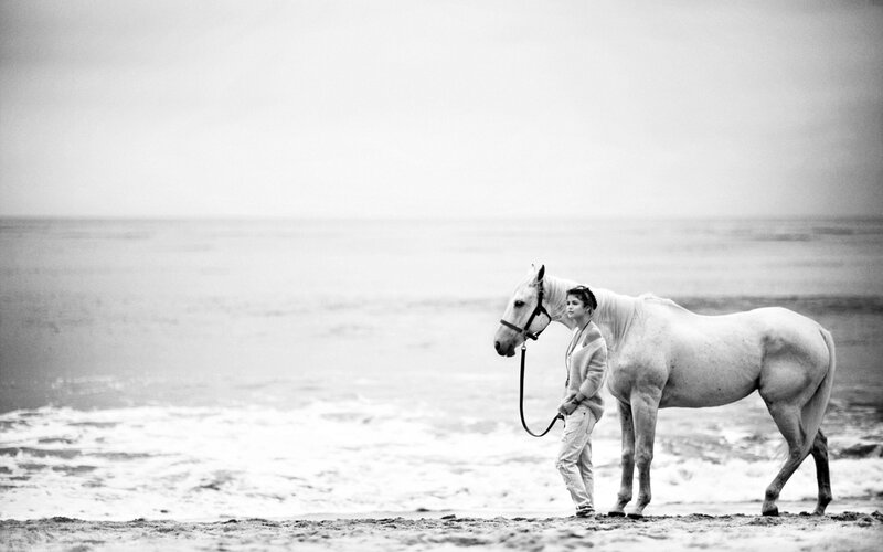 woman with horse on beach