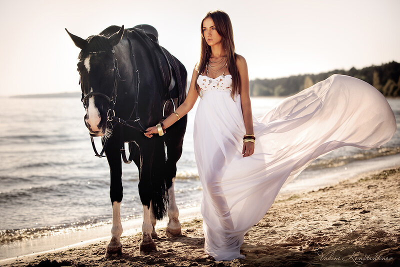 woman with horse on beach
