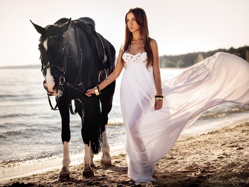 Woman with horse on beach