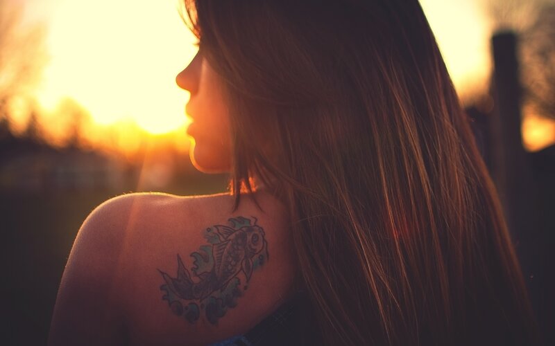 woman with koi tattoo at sunset