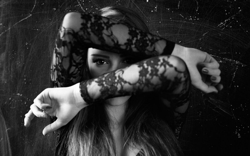woman with lace gloves covering face