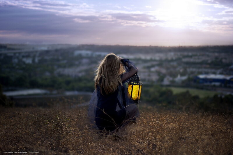 Woman with lantern on hill