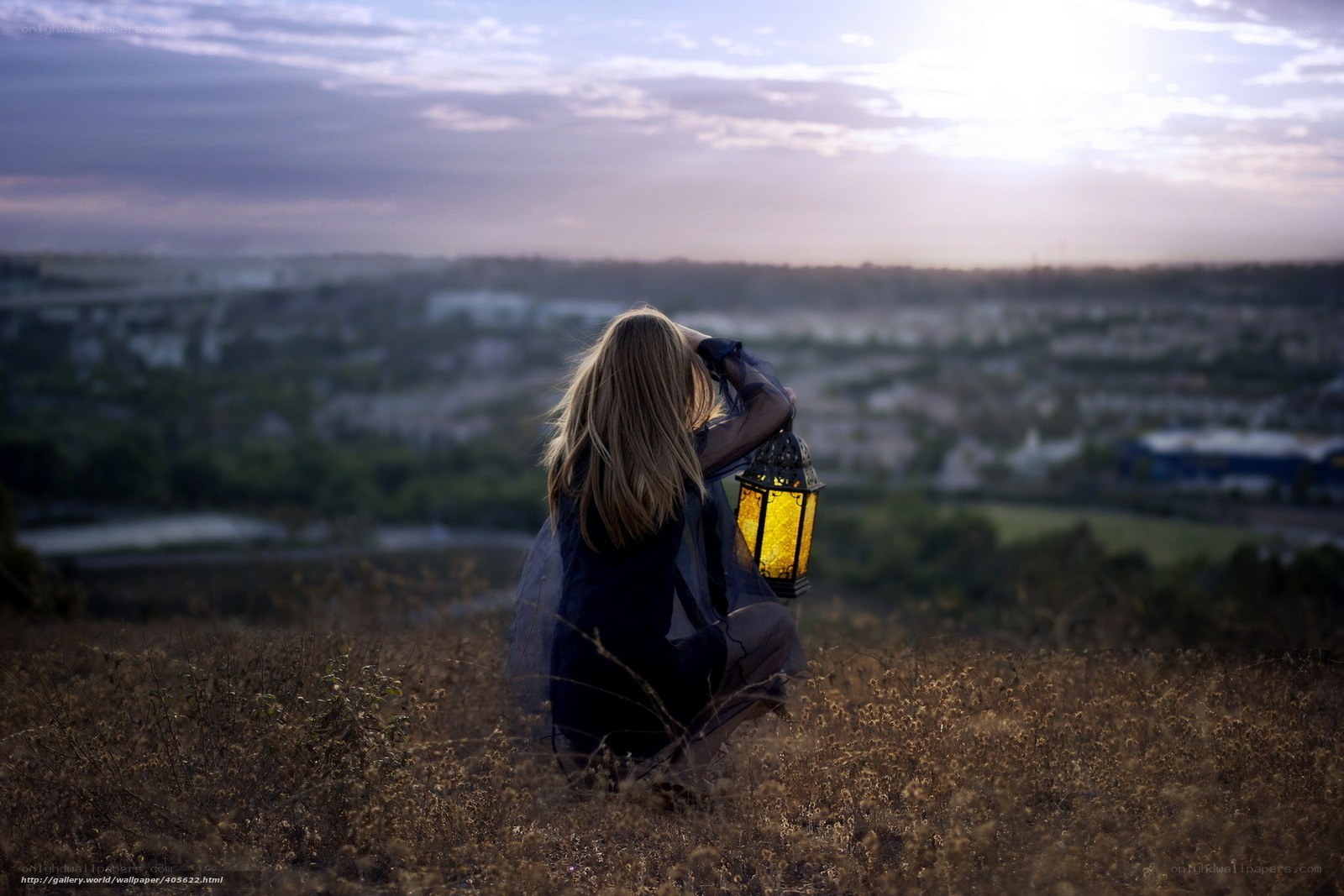 Woman with lantern on hill