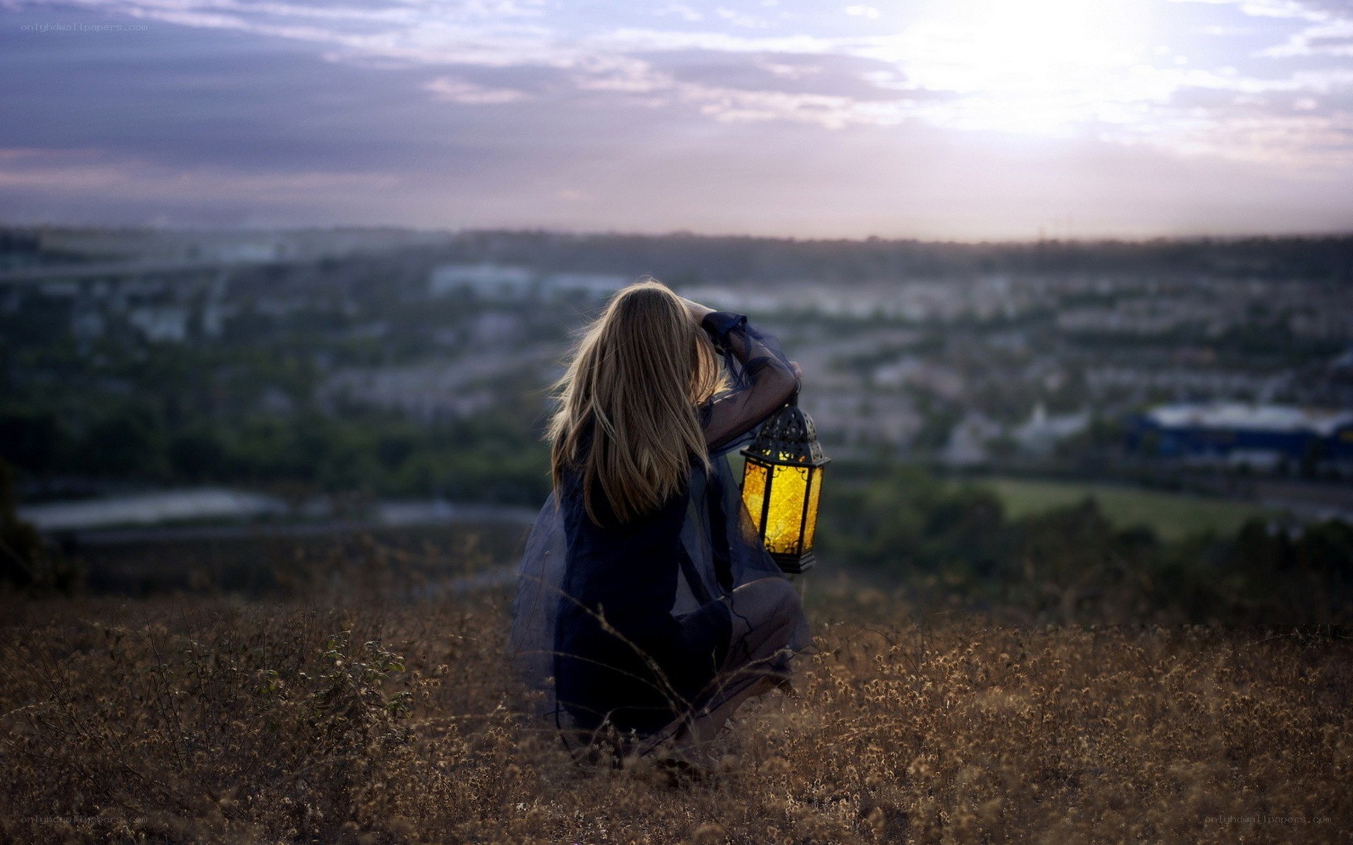 Woman with lantern on hillside