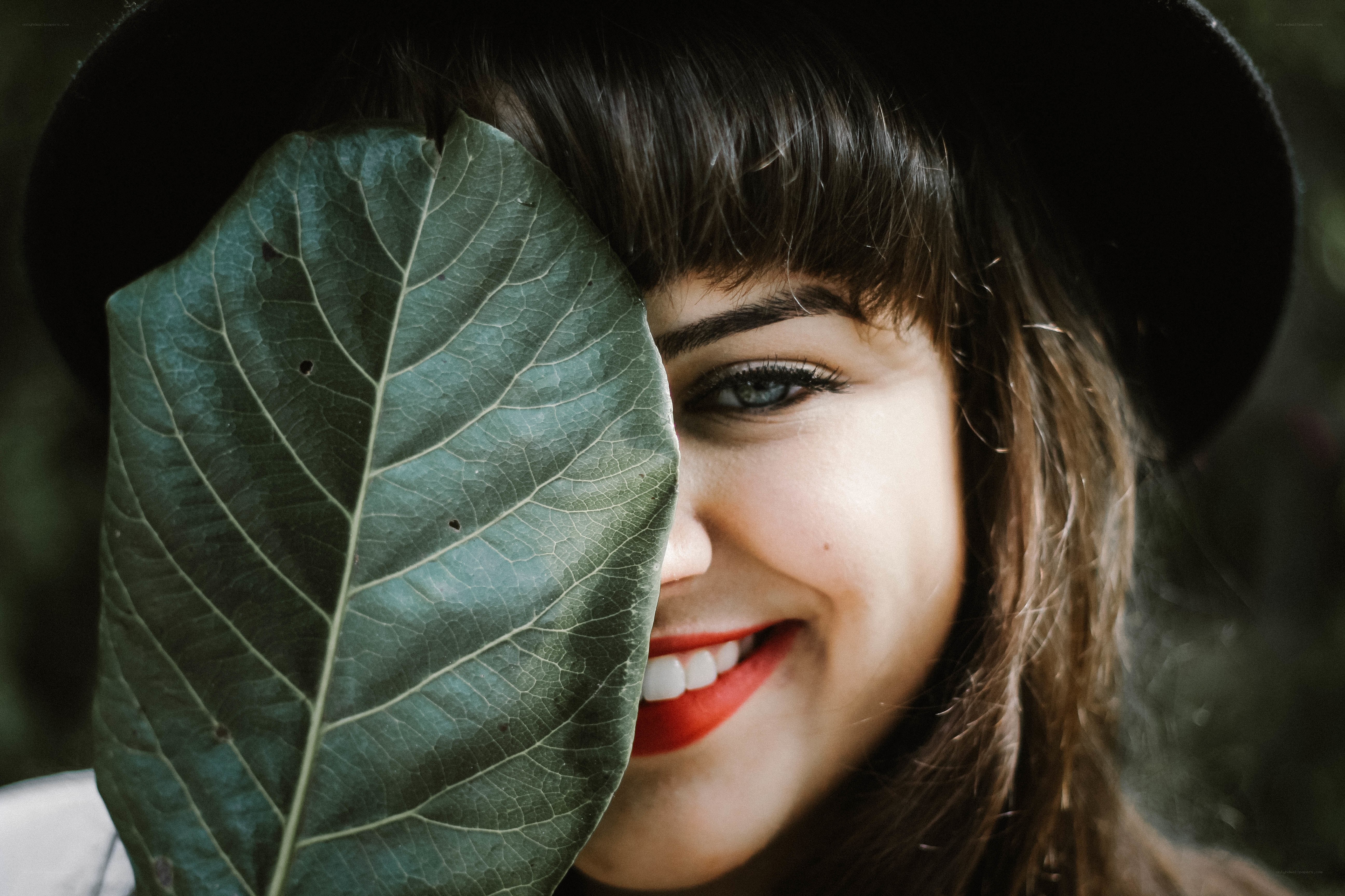 woman with leaf covering face