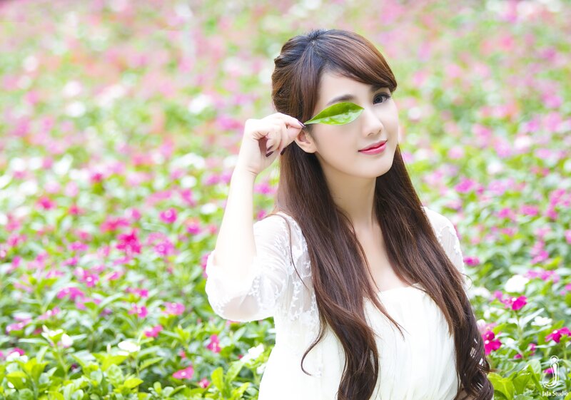 woman with leaf in flower field