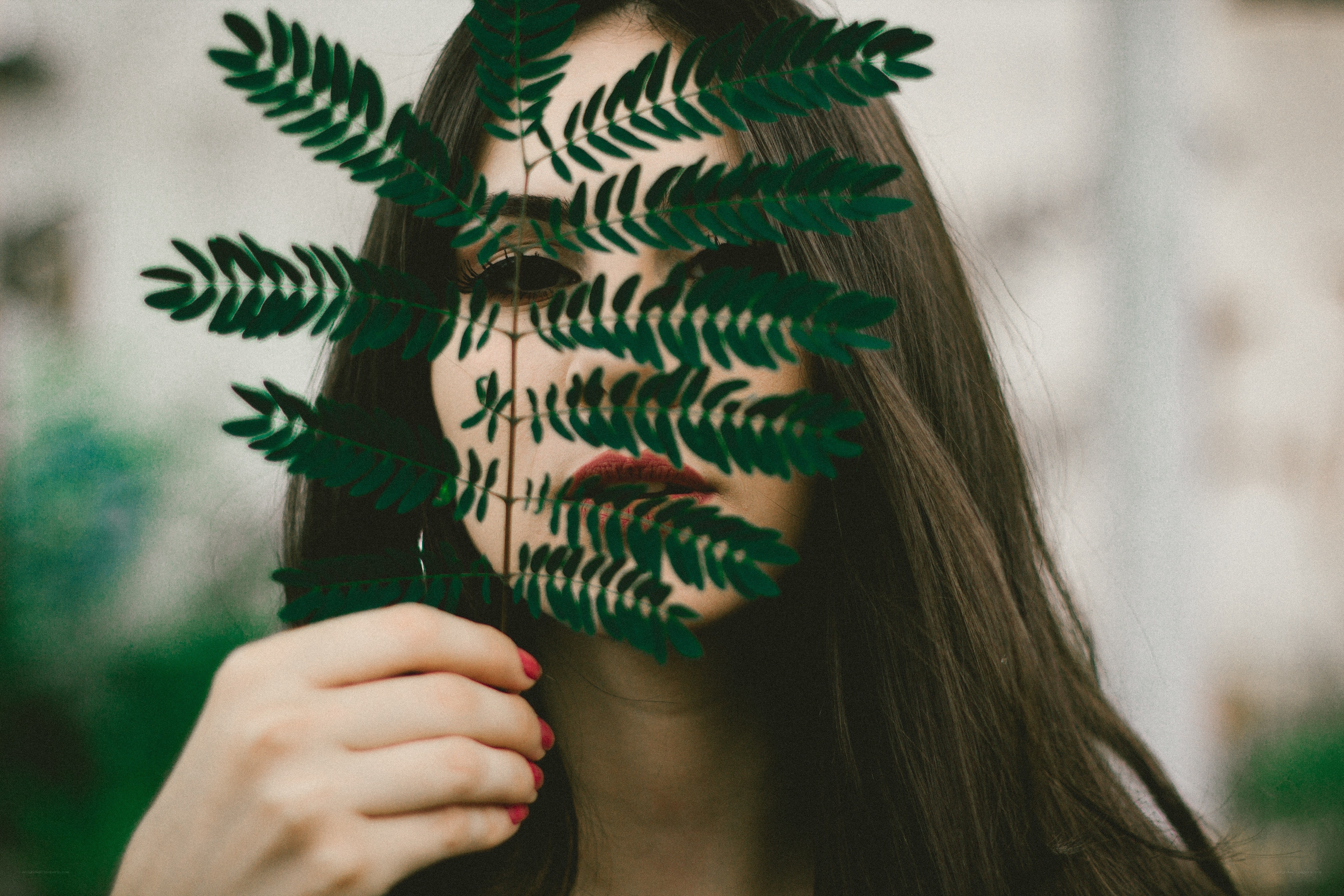 woman with leaf in front of face