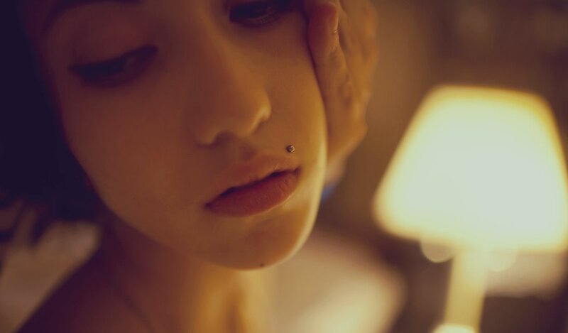 woman with lip piercing in dim light