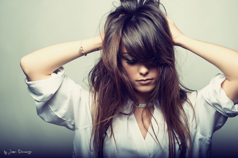 woman with long hair adjusting her hair