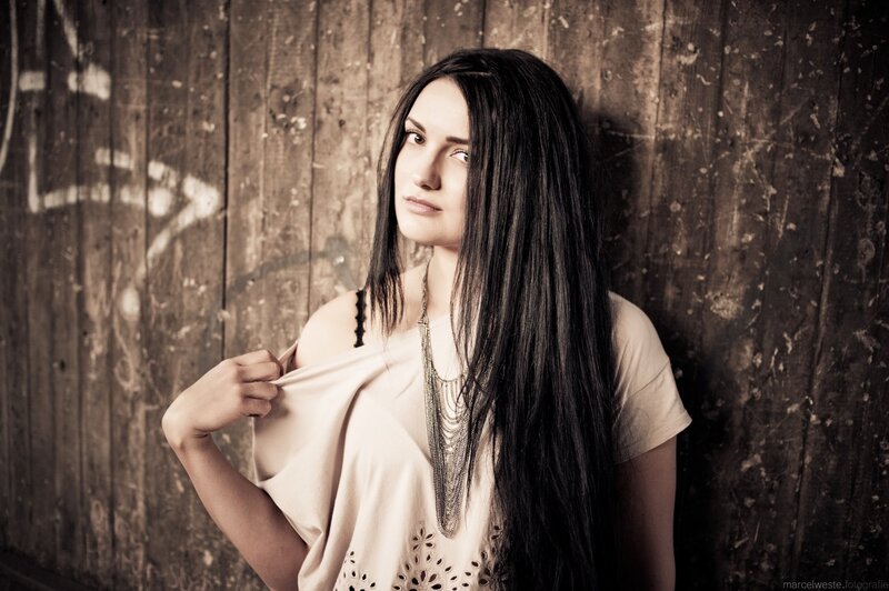 woman with long hair against wooden wall