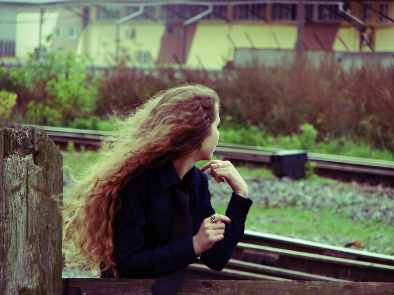 woman with long hair by train tracks