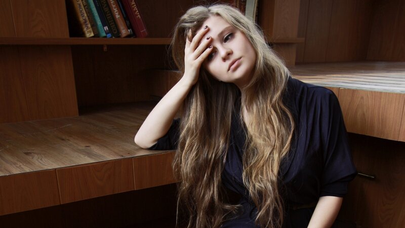 woman with long hair sitting at desk