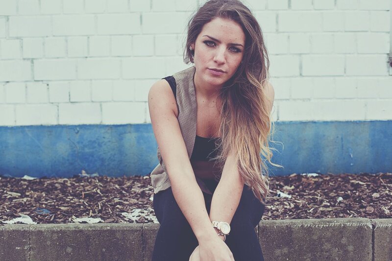 Woman with Long Hair — White, Serious, Photograph, Brick Wall