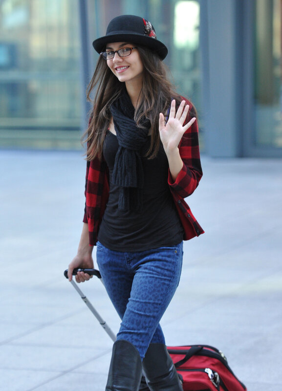 woman with luggage waving