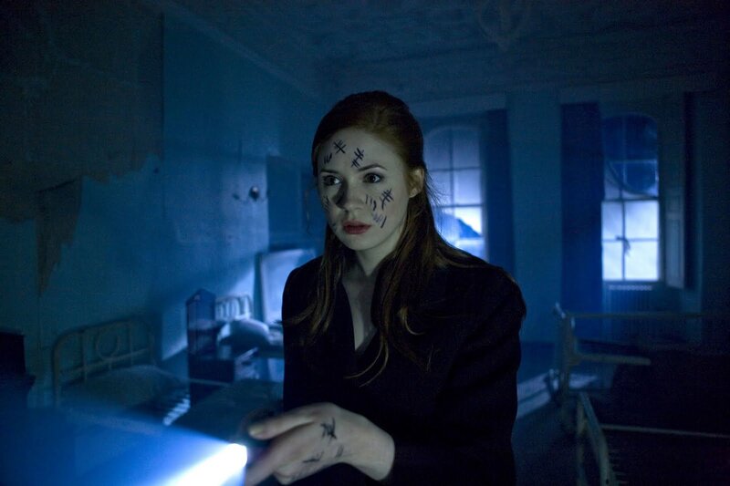 woman with markings in dark room