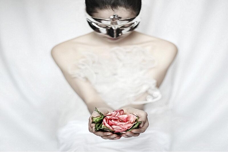 woman with mask holding rose